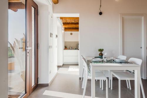 ein weißes Esszimmer mit einem weißen Tisch und Stühlen in der Unterkunft Dimora Pietra Nica in Cava dʼAliga
