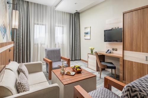 a living room of a hotel room with a couch and a table at Roots Hotel in Makkah