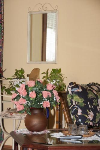 a room with a table with a vase of pink flowers at Bellevue Budapest B&B in Budapest