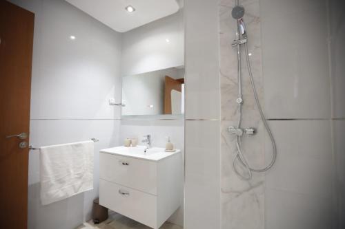 La salle de bains blanche est pourvue d'une douche et d'un lavabo. dans l'établissement APPARTEMENT RIAD WHITE GOLDEN, à Marrakech