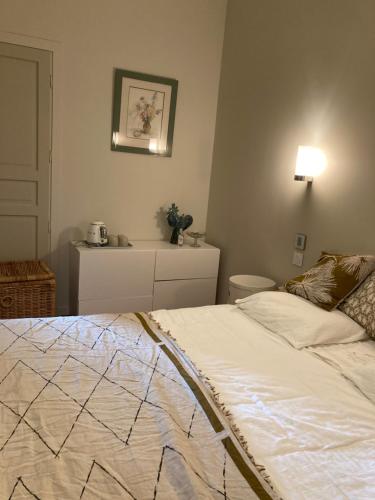 a bedroom with a bed and a table with a lamp at La villa des Amandiers in Hyères
