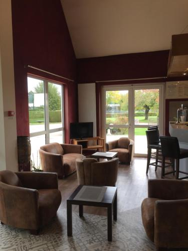 a living room with couches and tables and windows at Le Pavillon de Rouen in Franqueville-Saint-Pierre