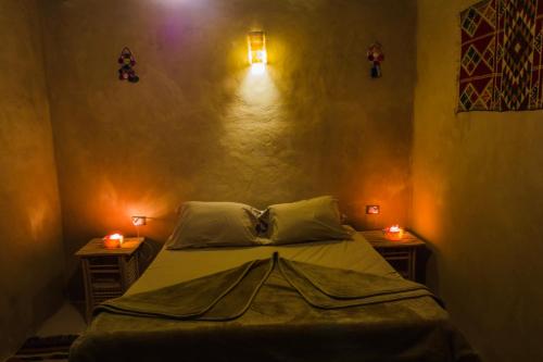 a bedroom with a bed with two lights on the wall at Seliyaa Siwa Inn Hotel in Siwa
