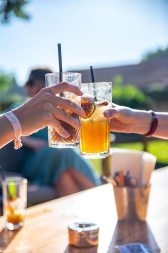 two people holding up glasses of drinks at a table at Domaine Gaogaia in Aix-en-Provence