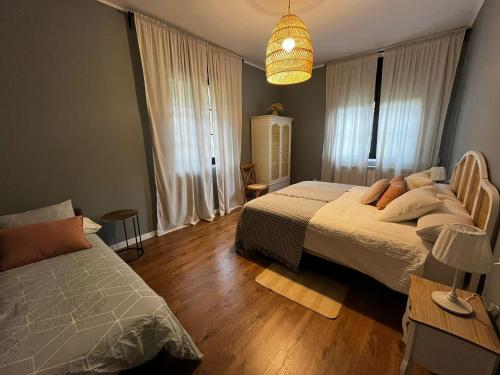 a bedroom with two beds and a chandelier at La Torre de Guardiola in Guardiola de Berguedà