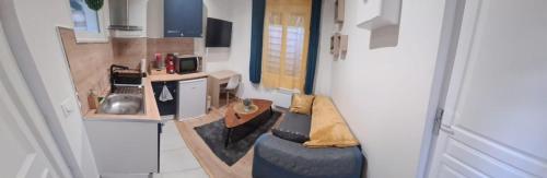a small apartment with a couch in a room at Petite maison cosy dans un jardin. in Ermont