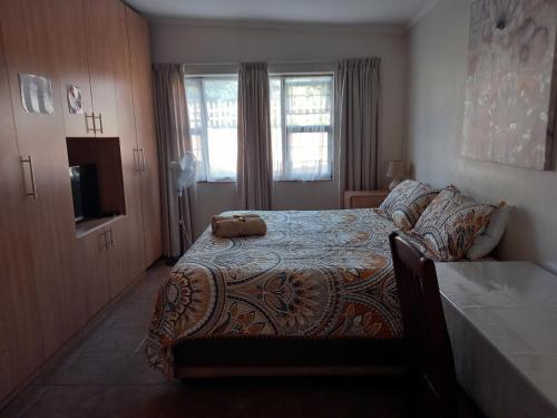 1 dormitorio con 1 cama y TV en White Rose Guest House, en Vanderbijlpark