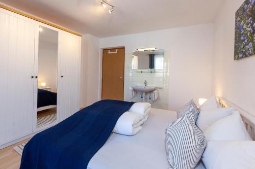 a bedroom with a large white bed and a bathroom at Apart Plangger in Nauders