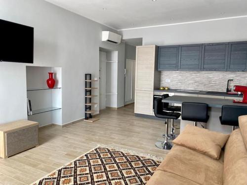 ein Wohnzimmer mit einem Sofa und einer Küche in der Unterkunft Appartamento centralissimo in Piazza Bresca in Sanremo