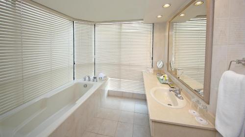 a bathroom with a tub and a sink and a mirror at Intercontinental Miramar Panama by IHG in Panama City