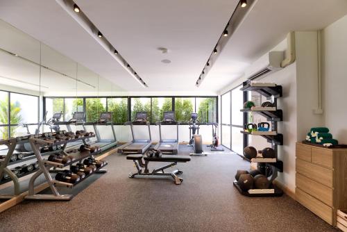 a gym with lots of treadmills and machines at OUTRIGGER Surin Beach Resort in Surin Beach
