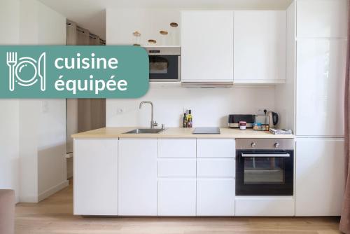 une cuisine avec des placards blancs et un appareil de cuisine textuelle dans l'établissement Appartement Cosy Lyon Ouest Tassin, à Tassin-la-Demi-Lune