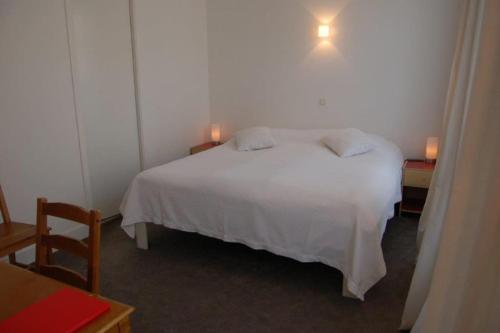 una camera da letto con un letto bianco con due luci sopra di Casa Nova Scheveningen a Scheveningen