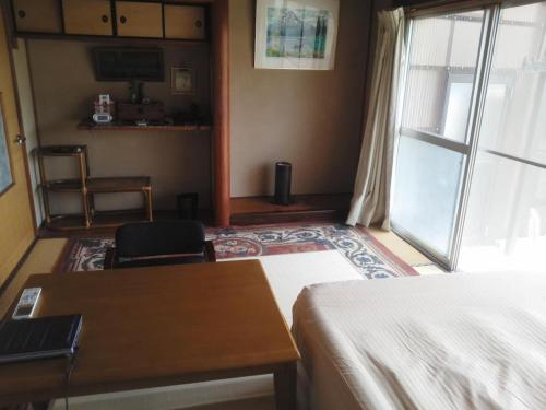 - une chambre avec un lit, un bureau et une fenêtre dans l'établissement Guesthouse Farmor - Vacation STAY 15083v, à Imabari