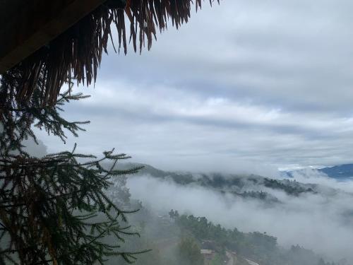 a view of a mountain covered in fog and clouds at Riz d'Or Ermitage - Hoang Su Phi in Hoàng Su Phì