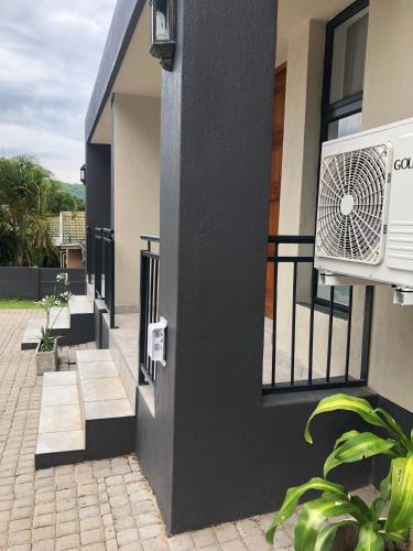 un aire acondicionado blanco en el lateral de un edificio en Spring Acres Guesthouse, en Nelspruit