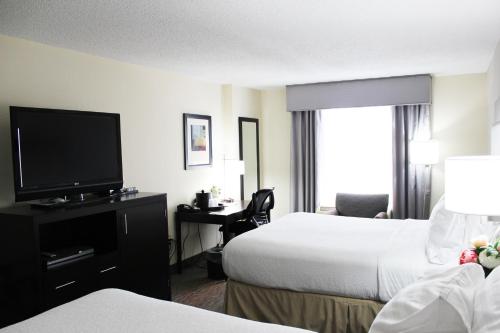 アトランタにあるHoliday Inn Hotel Atlanta-Northlake, a Full Service Hotelのベッド2台、薄型テレビが備わるホテルルームです。