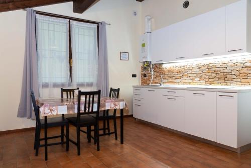 une cuisine avec une table et des chaises ainsi qu'un mur en briques dans l'établissement Il Falco, à Castellarano