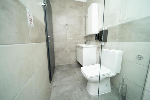 y baño con aseo y ducha acristalada. en Darija Apartments - City Square, en Ohrid