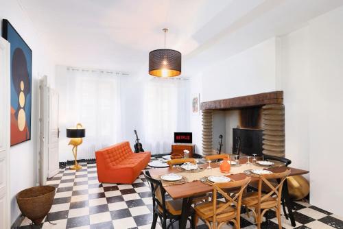 une salle à manger avec une table et une cheminée dans l'établissement L'Hôtel Particulier, 120m2, Hypercentre, Wifi / ConciergerieDameCarcas, à Carcassonne