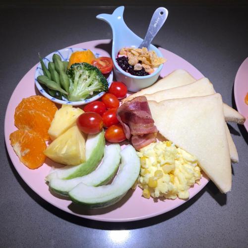 a pink plate of food with vegetables and fruit at Hi Kids B&B in Zhixue