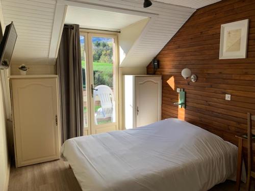 a bedroom with a white bed and a window at Au Sans Souci in Saint-Paul-lès-Monestier