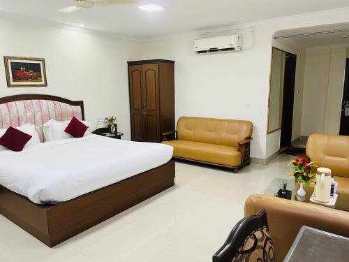 a hotel room with a bed and a couch at Bodhgaya Regency Hotel in Bodh Gaya