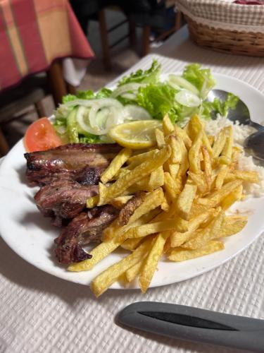 a plate of food with french fries and meat at Summer holiday in Fernao Ferro