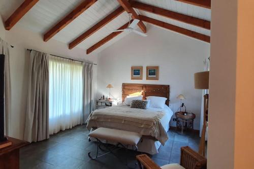 a bedroom with a large bed and a large window at Casa privada amplia y tranquila, rodeada de naturaleza. in Lago Puelo