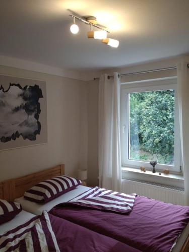a bedroom with a bed and a window at FeWo Wolfseiche in Jänkendorf