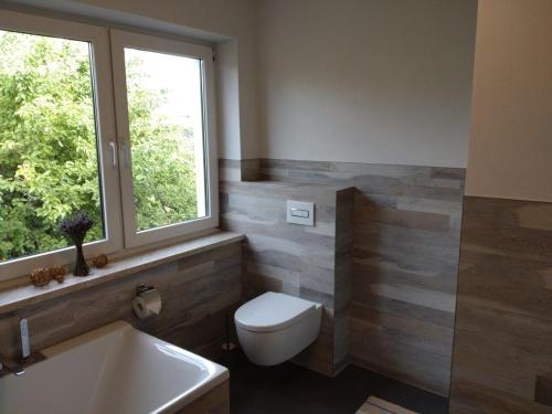 a bathroom with a toilet and a window and a sink at FeWo Wolfseiche in Jänkendorf