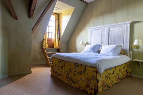 een slaapkamer met een bed met witte lakens en een raam bij B&B Kasteelhoeve de Kerckhem in Wijer