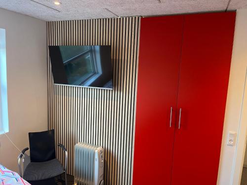 a room with a tv and a red cabinet at Nice villa near nature and the city in Silkeborg