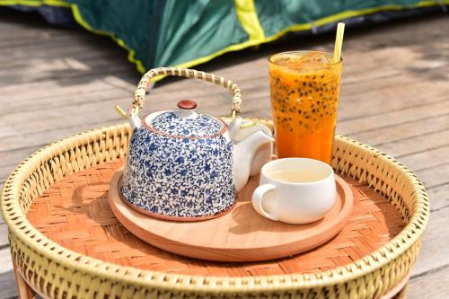 a tray with a tea pot and a drink at La Villa Hortensia-Mondulkiri in Phumĭ Pu Pal