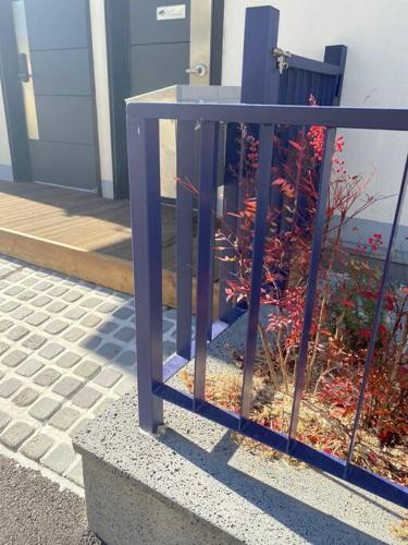 a blue fence in front of a building at Gyeongju Sugi's Guesthouse in Gyeongju