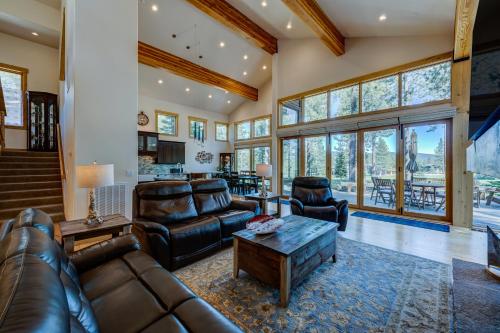 a living room with leather furniture and large windows at Sierra Vista in Truckee