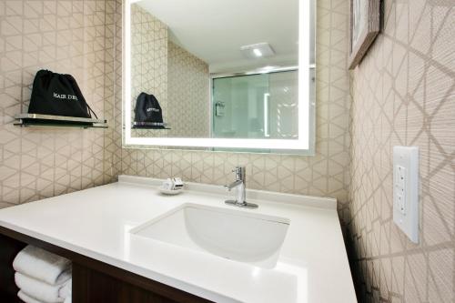 a bathroom with a white sink and a mirror at Holiday Inn Va Beach-Oceanside 21st St by IHG in Virginia Beach