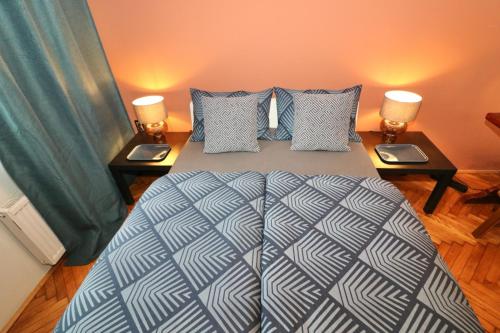 sypialnia z dużym łóżkiem z dwoma stolikami nocnymi w obiekcie Studio City w Lublanie