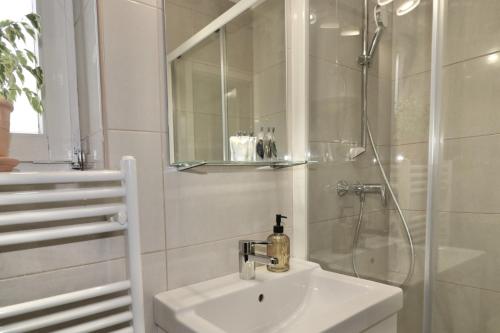 a white bathroom with a sink and a shower at Studio City in Ljubljana