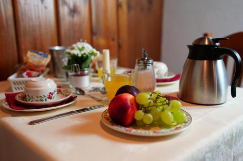 un tavolo con un piatto di frutta e un bollitore per il tè di Hotel Cime Bianche a Breuil-Cervinia