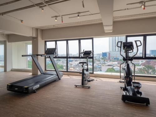 a gym with treadmills and exercise bikes in a room at Apartemen Grand Jati Junction Medan 3 Kamar in Medan