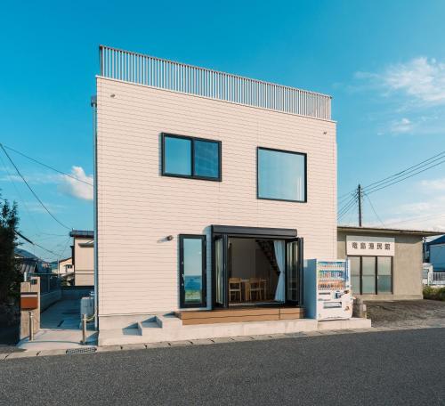 a house with a large window on the side of it at Ryu shi ma Ocean View Villa in Kyonan