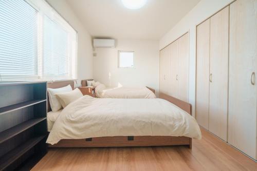 a bedroom with two beds and a large window at Ryū shi ma Ocean View Villa in Kyonan