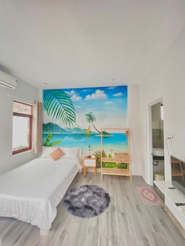 a bedroom with a bed and a painting of a beach at Tùng Homestay in Hue