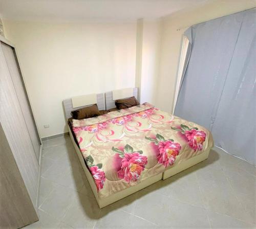 łóżko z różowymi kwiatami w pokoju w obiekcie The view 43 - C4 w Szarm el-Szejk