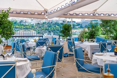 un restaurante con sillas azules y mesas en la azotea en Port Palace en Montecarlo