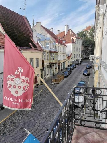 a flag on a balcony of a street with buildings at St.Olav Hotel in Tallinn
