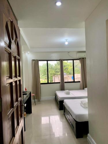 a bedroom with two beds and a window at Adelaida Pensionne Hotel in Bantayan Island