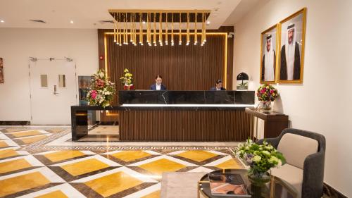 a lobby of a hotel with two people in the lobby at Somerset Al Mansoura Doha in Doha