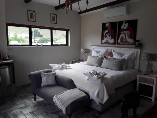 a bedroom with a large bed and a chair at Monas Risibiki Westside in Kleinmond